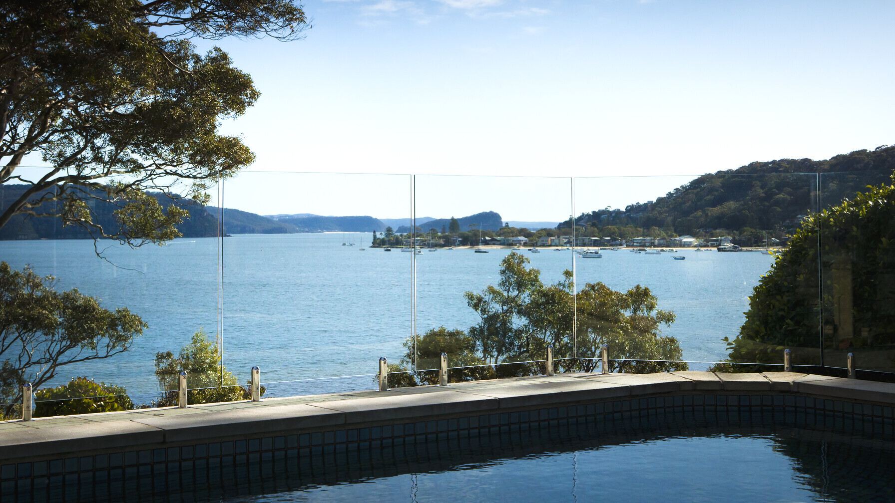 Real frameless glass pool fence with stainless-steel spigots overlooking Pittwater at Clareville